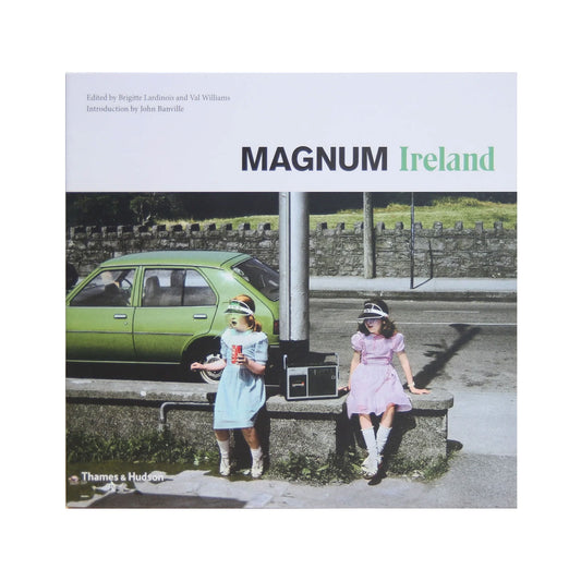 Cover of the book 'Magnum Ireland' featuring two young children playing with a toy car on a roadside, with a green car in the background.